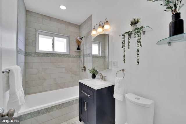 full bath with tiled shower / bath combo, toilet, and vanity