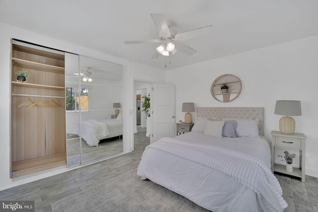 bedroom featuring ceiling fan, a closet, and wood finished floors