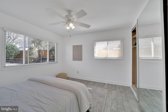 bedroom with ceiling fan, baseboards, and wood finished floors