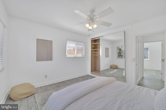 bedroom featuring a closet, baseboards, and wood finished floors