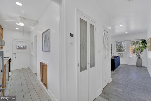 hallway featuring baseboards, light wood-style flooring, and recessed lighting