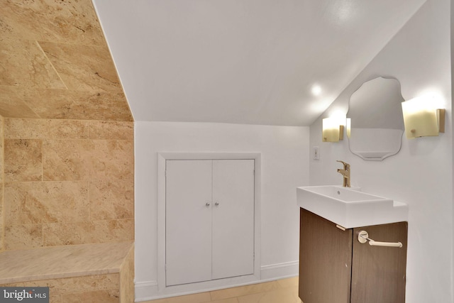 bathroom featuring vaulted ceiling and vanity