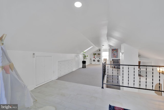 bonus room with vaulted ceiling and carpet flooring