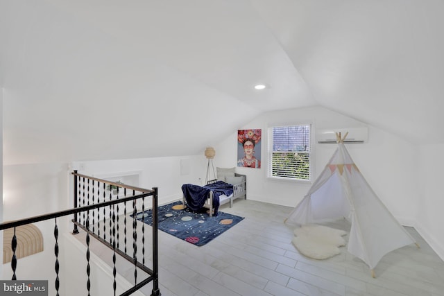 interior space featuring light wood finished floors, recessed lighting, vaulted ceiling, a wall mounted air conditioner, and baseboards