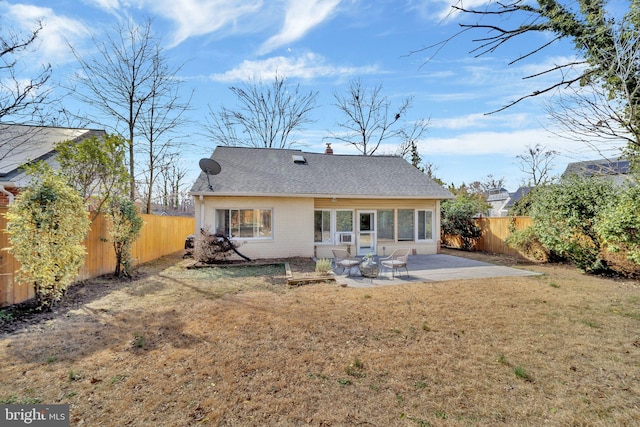 rear view of property with a patio, a fenced backyard, a shingled roof, brick siding, and a yard