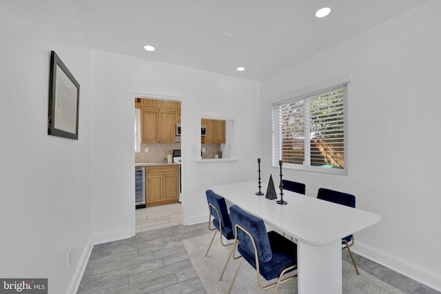 dining space with wood tiled floor, wine cooler, baseboards, and recessed lighting