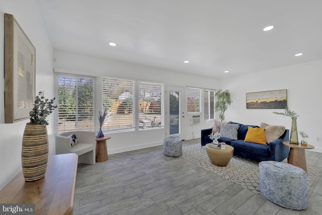 living area featuring recessed lighting, a healthy amount of sunlight, baseboards, and wood finished floors