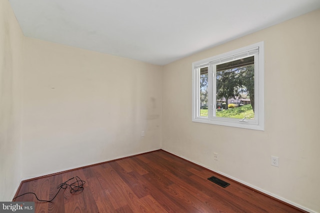 empty room featuring visible vents and dark wood finished floors