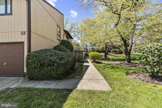 view of property exterior featuring a garage and a lawn