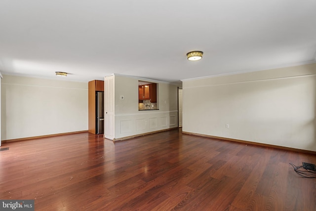 unfurnished living room featuring dark wood-type flooring, crown molding, and visible vents