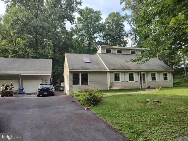 view of front of home with a front yard, a garage, and driveway