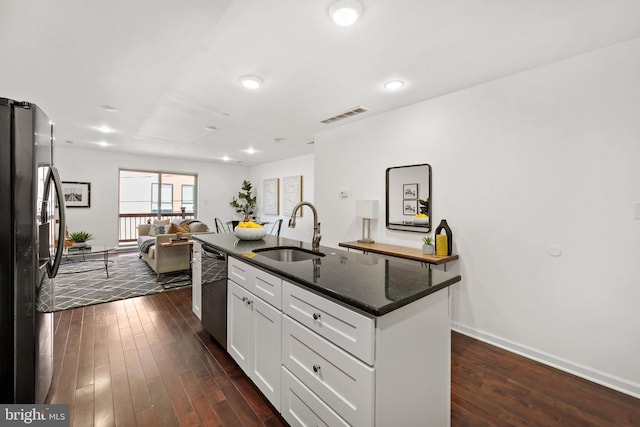 kitchen featuring sink, black fridge, stainless steel dishwasher, a kitchen island with sink, and white cabinets