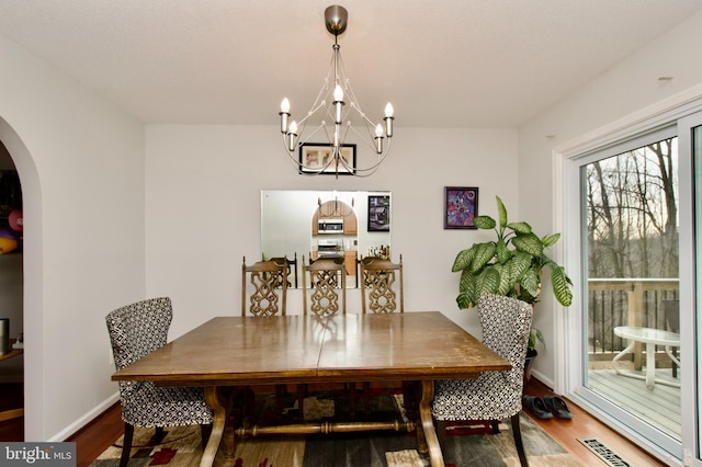 dining space featuring hardwood / wood-style flooring and a chandelier