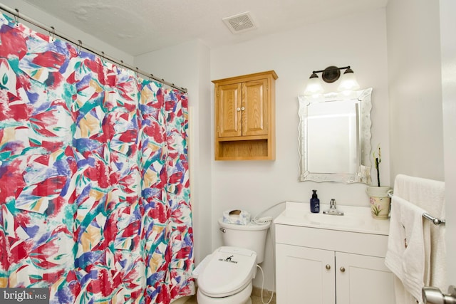 bathroom featuring toilet, vanity, and curtained shower