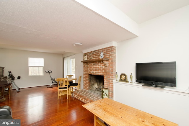 living room featuring a fireplace, dark wood-type flooring, and a textured ceiling