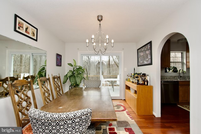 dining room with sink, a notable chandelier, and wood-type flooring