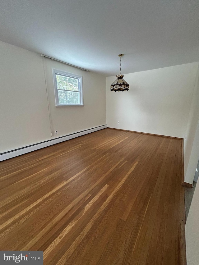 spare room with a baseboard radiator and wood-type flooring