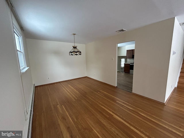 unfurnished dining area with dark hardwood / wood-style floors and baseboard heating