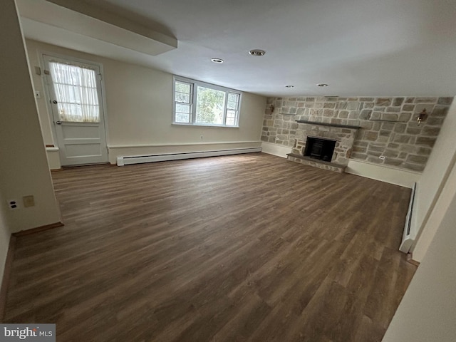 unfurnished living room featuring dark wood-type flooring, a fireplace, and baseboard heating