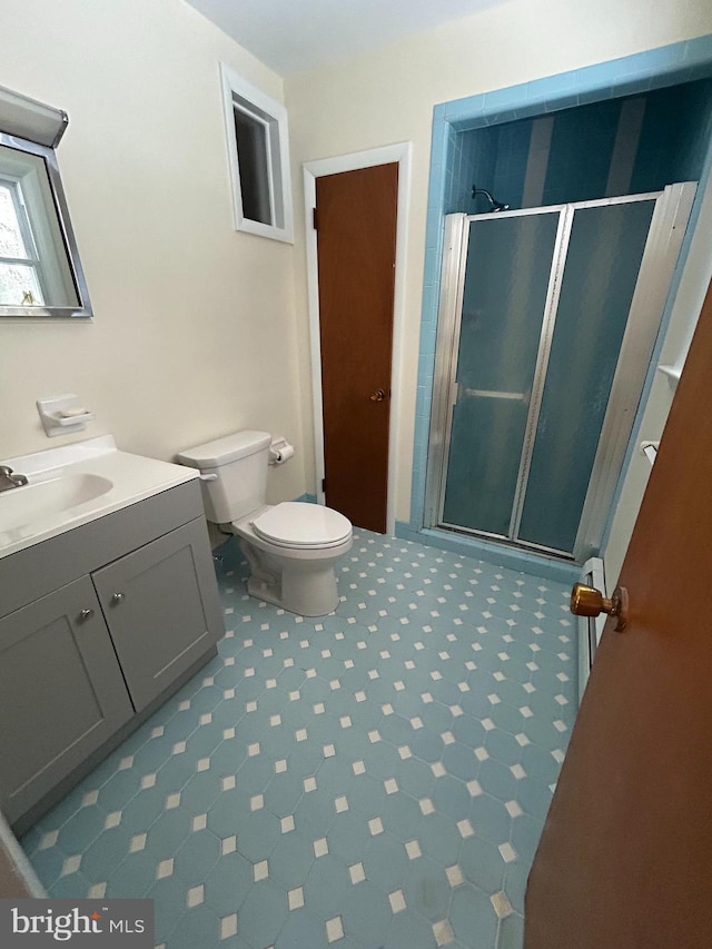 bathroom with an enclosed shower, vanity, and toilet