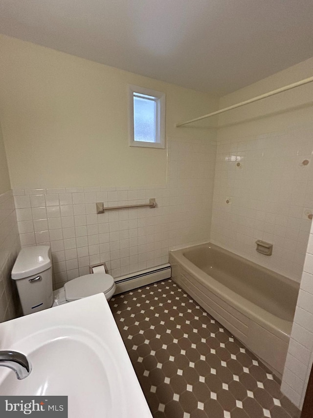 full bathroom with sink, shower / tub combination, baseboard heating, tile walls, and toilet