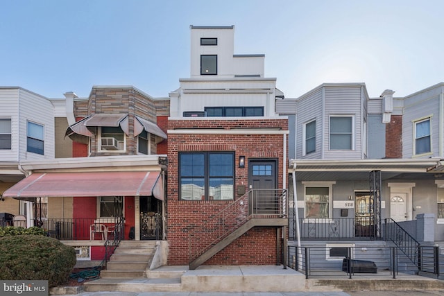 multi unit property with a porch and brick siding