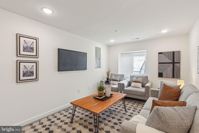 living room with electric panel, baseboards, and recessed lighting