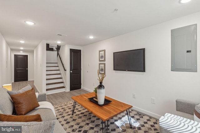 living room with baseboards, electric panel, stairway, and recessed lighting