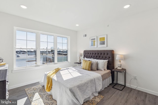 bedroom with recessed lighting, visible vents, baseboards, and wood finished floors