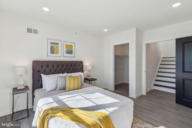 bedroom featuring baseboards, wood finished floors, visible vents, and recessed lighting