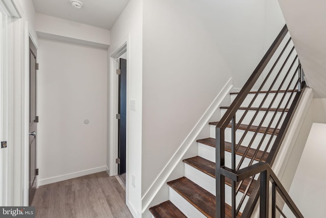 stairway with baseboards and wood finished floors