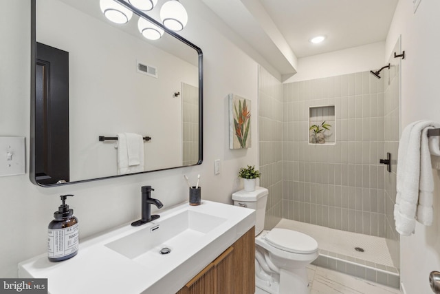 full bathroom featuring visible vents, vanity, toilet, and tiled shower