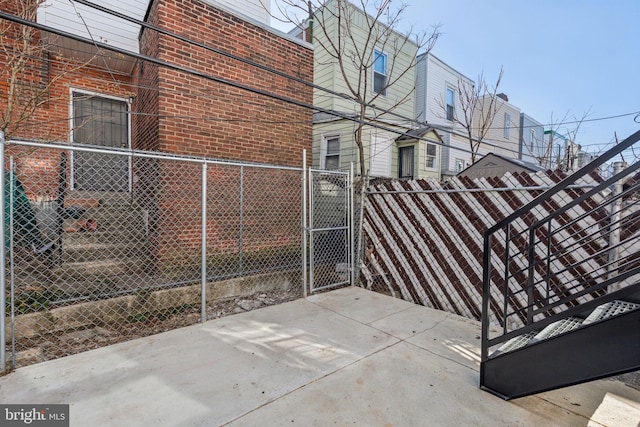 view of property exterior featuring a gate, brick siding, and fence