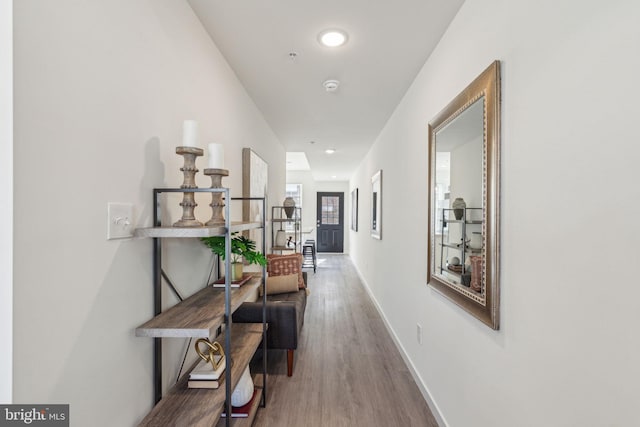 hallway featuring recessed lighting, baseboards, and wood finished floors