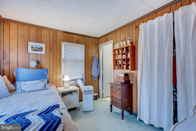 bedroom with wooden walls, light colored carpet, and ornamental molding