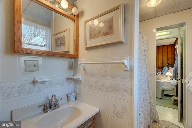 bathroom featuring backsplash, tile walls, and vanity