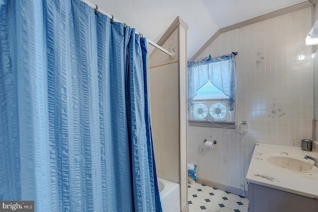 full bath with tile patterned floors, shower / bath combination with curtain, tile walls, and vanity