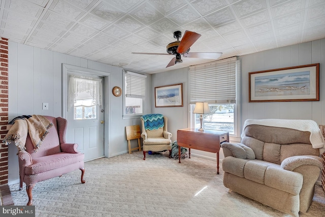 living area with baseboards, carpet floors, and ceiling fan