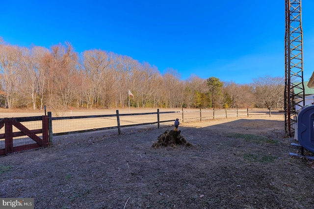 view of yard featuring a rural view, heating fuel, and fence