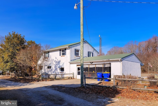 view of front facade featuring fence and metal roof