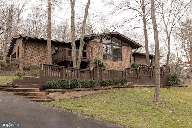 view of front of property featuring a wooden deck and a front lawn