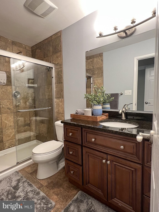 bathroom with vanity, an enclosed shower, and toilet