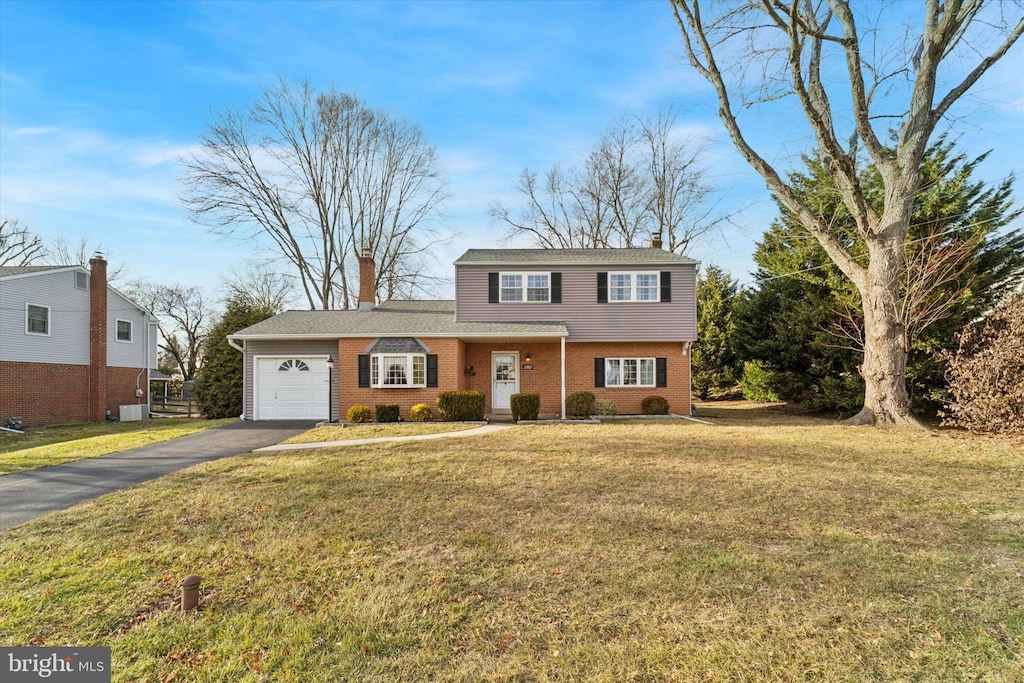 view of property featuring a garage and a front lawn