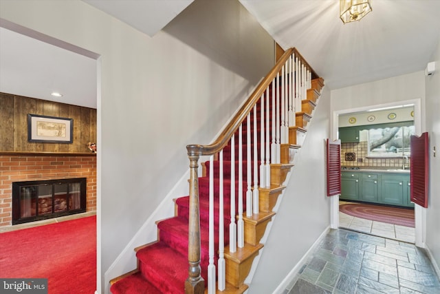 staircase with sink and a fireplace