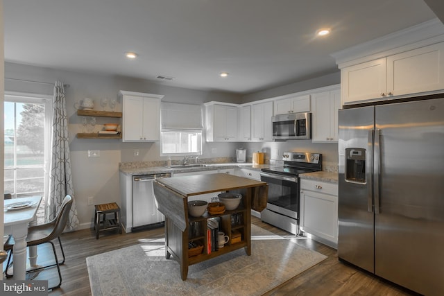 kitchen with stainless steel appliances, white cabinetry, and open shelves