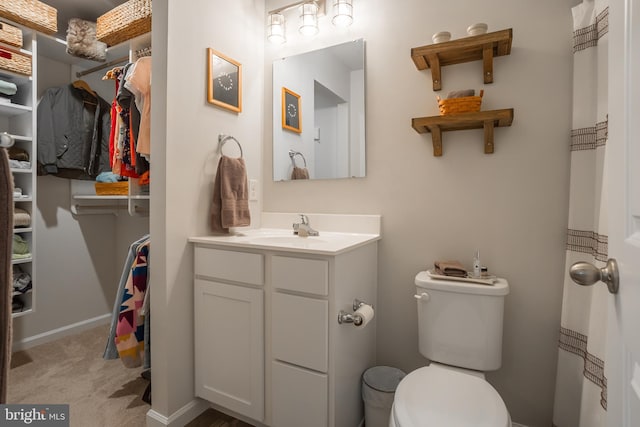 bathroom with toilet, baseboards, and vanity