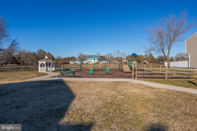 community playground with a lawn, a gazebo, and fence