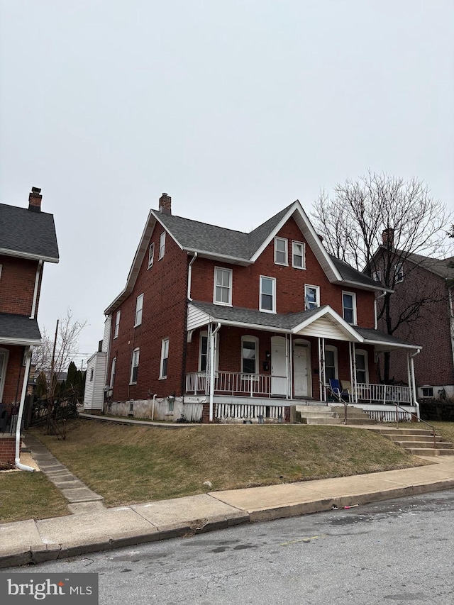 view of front of house with covered porch and a front yard