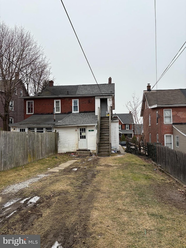 rear view of property featuring a lawn