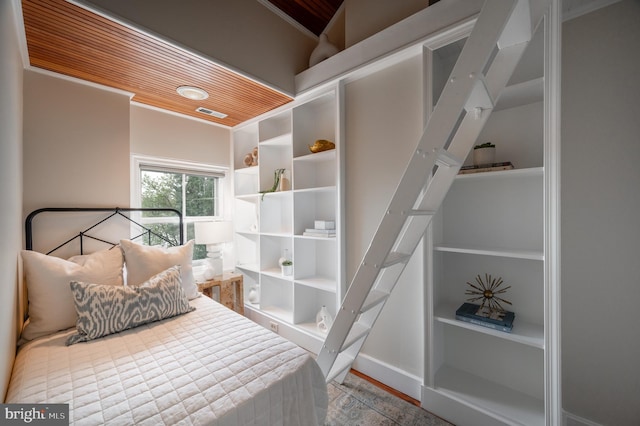 bedroom with visible vents, crown molding, and wood finished floors
